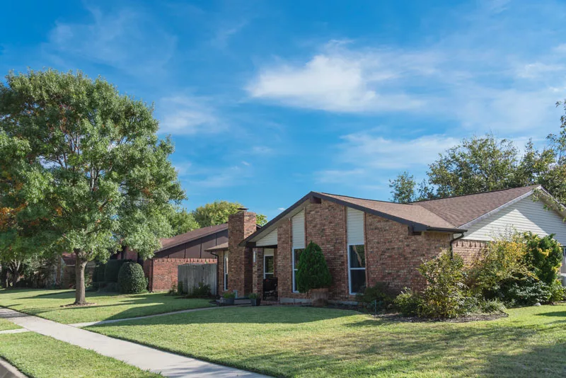 Brick home under a blue sky, protected with home insurance in Frisco, TX