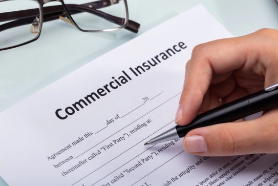 A Hand Signing a Commercial Insurance Contract for a Business in the Woodlands